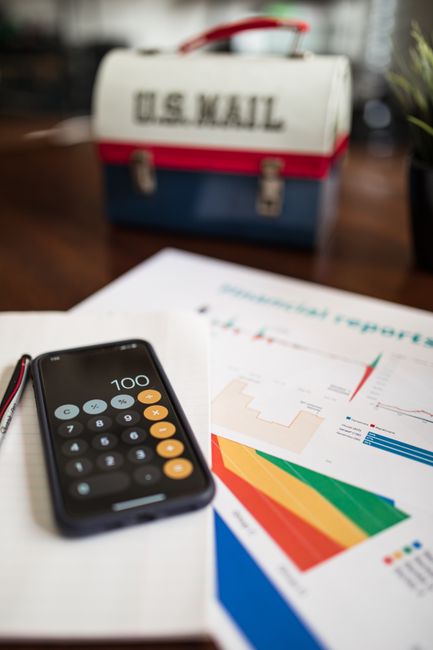 A professional calculator placed next to a smartphone showing a clean finance report chart. A professional calculator placed next to a smartphone showing a clean finance report chart.