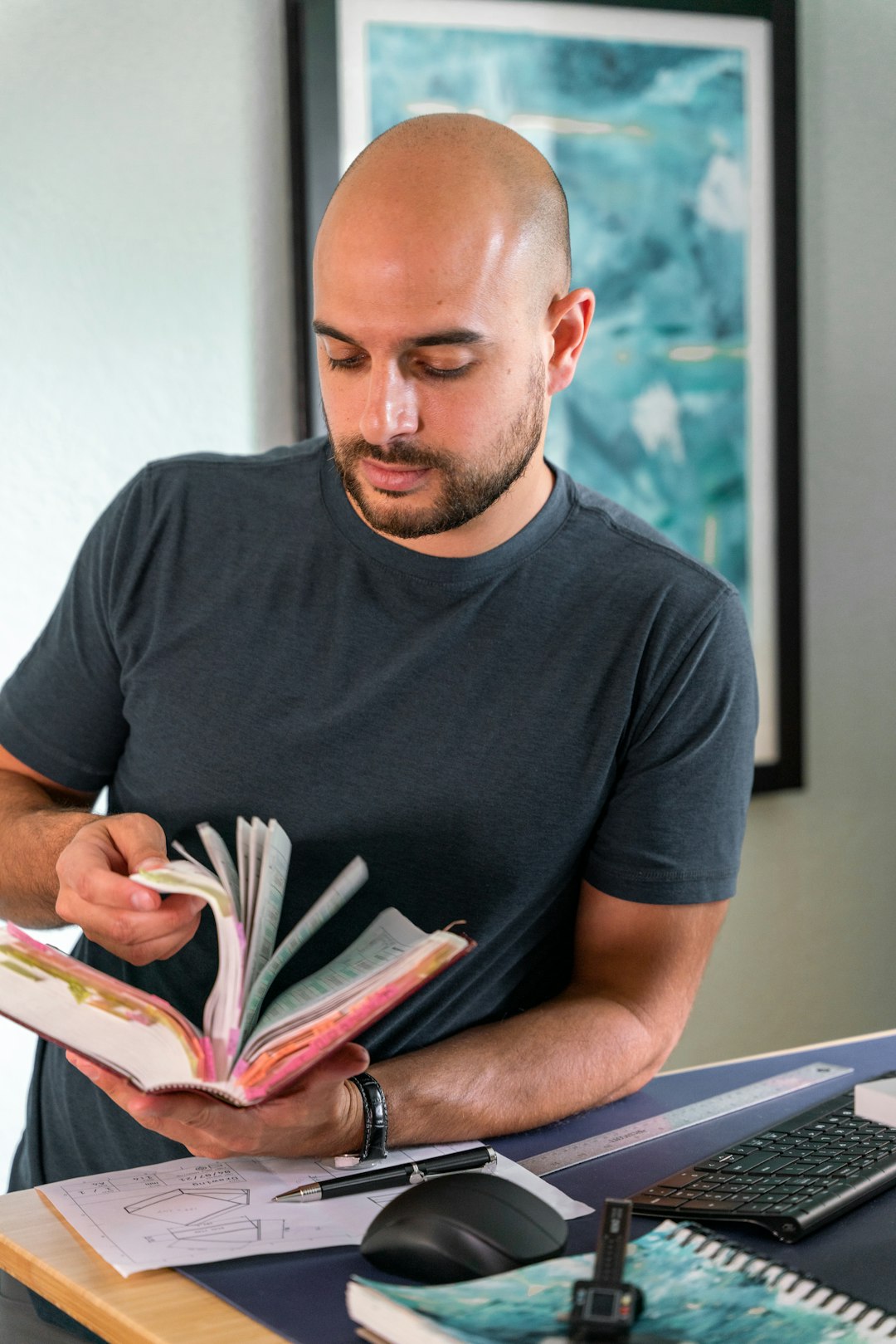 A professional book author sitting at a desk surrounded by tech-focused notebooks and architectural schema printouts A professional book author sitting at a desk surrounded by tech-focused notebooks and architectural schema printouts