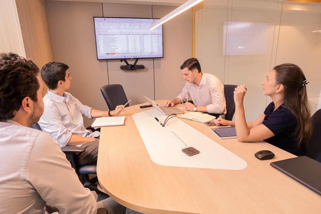 A corporate boardroom setting where participants use digital tablet devices connected via a unified blockchain, showing transparent data flows A corporate boardroom setting where participants use digital tablet devices connected via a unified blockchain, showing transparent data flows