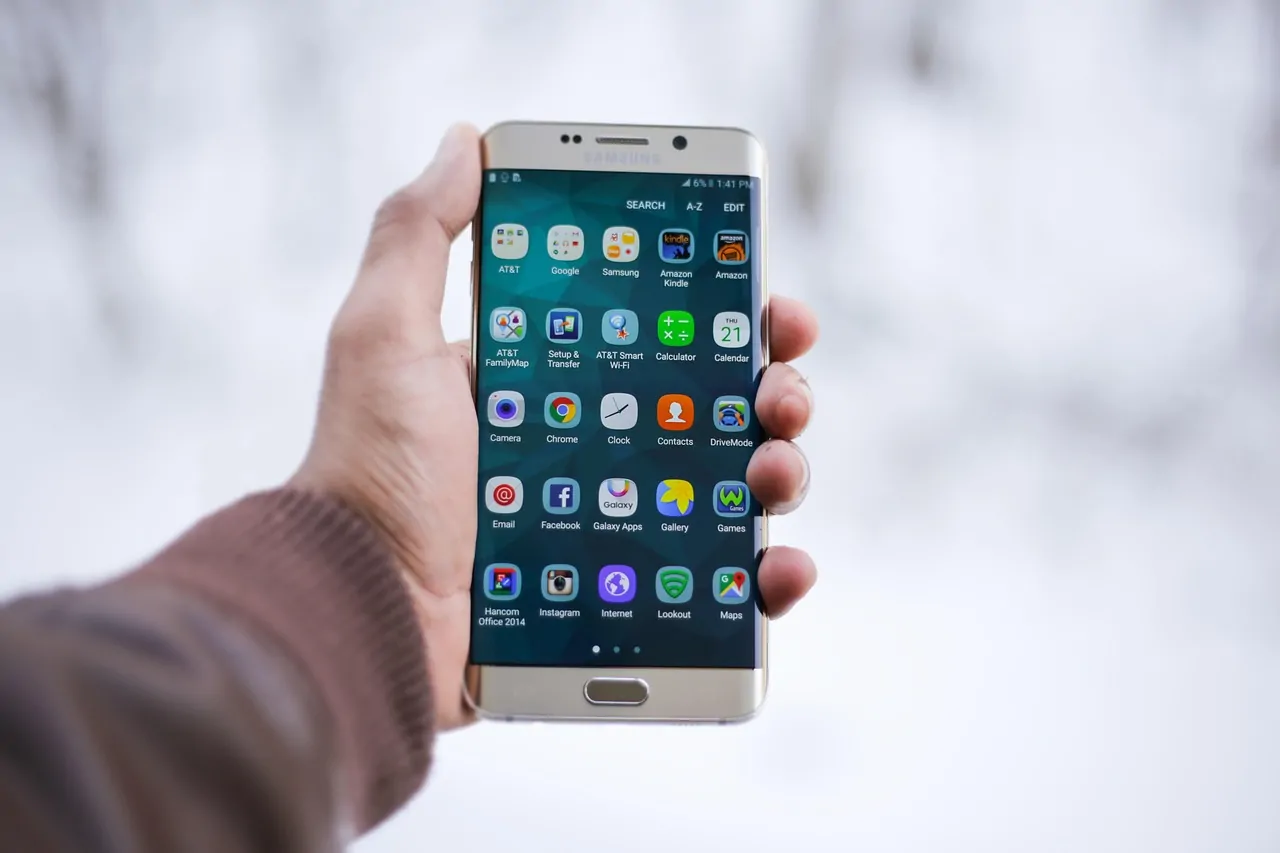 Hands holding smartphone showing balanced wallet interface with hardware confirmation prompt Hands holding smartphone showing balanced wallet interface with hardware confirmation prompt
