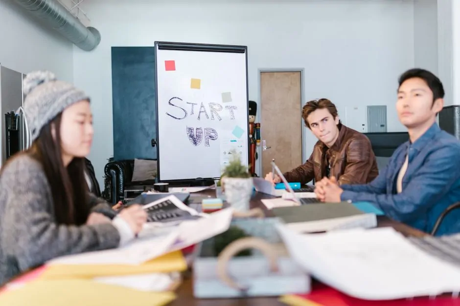 A modern office setting with founders presenting their pitch deck to venture capital investors in a boardroom. A modern office setting with founders presenting their pitch deck to venture capital investors in a boardroom.