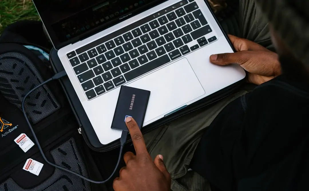Person reviewing a crypto transaction on a laptop beside a locked hardware wallet Person reviewing a crypto transaction on a laptop beside a locked hardware wallet